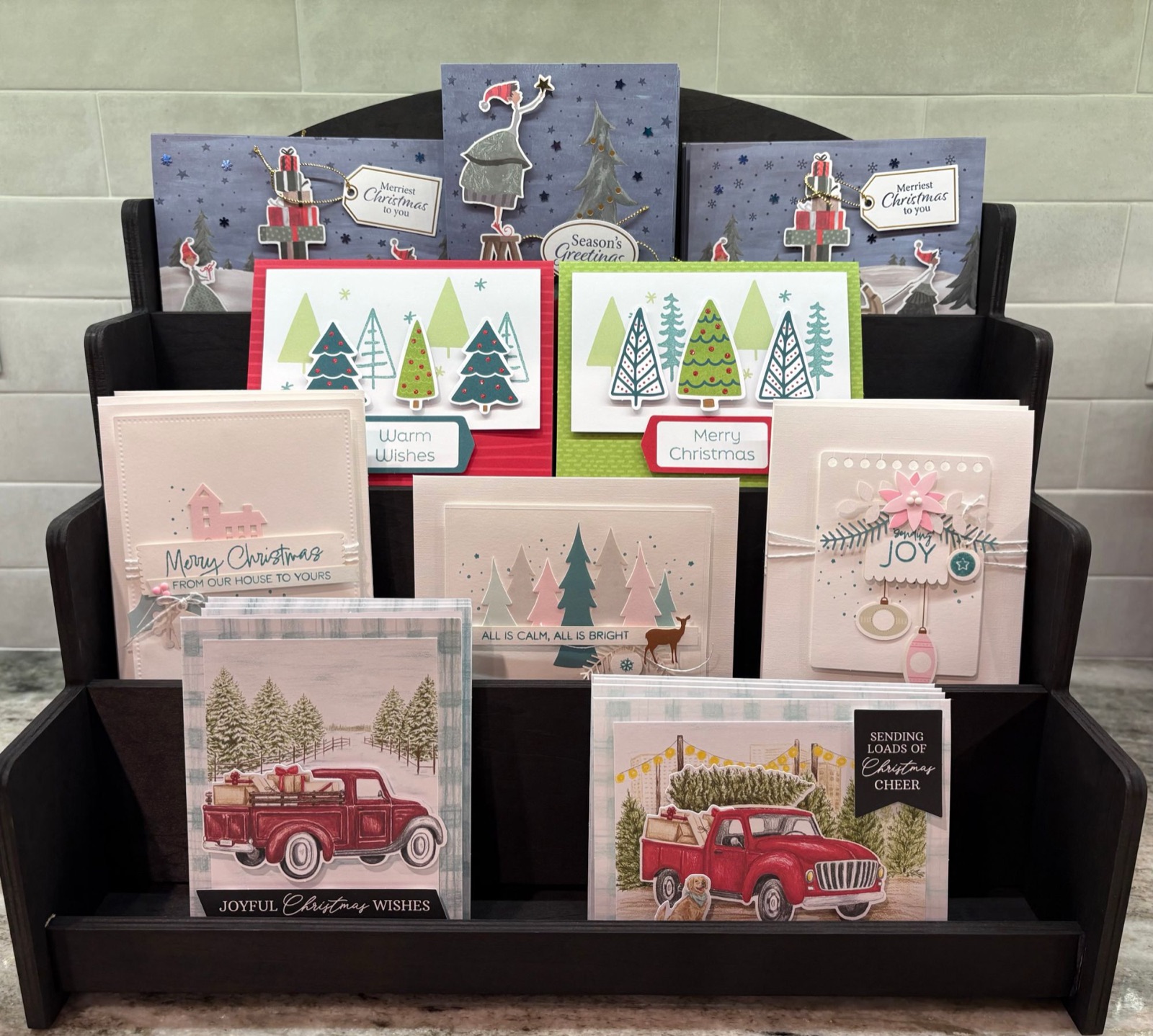 Display of handmade Christmas cards featuring trees and red trucks