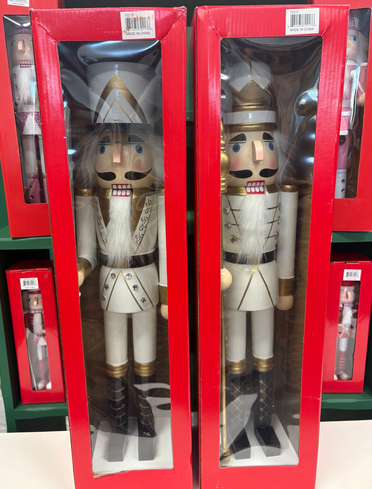 Tall white and gold nutcrackers in red display boxes